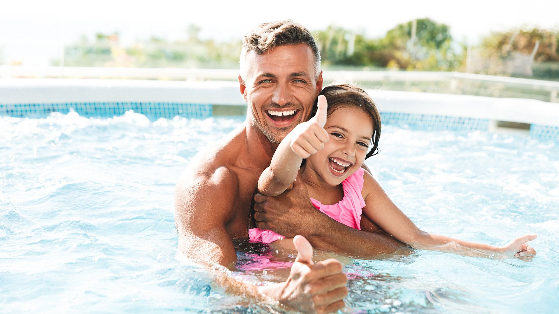 Vater und Tochter haben zusammen Spaß im Pool